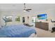 Bedroom with a ceiling fan, large windows, TV, dresser and workout equipment at 824 W Mesquite St, Gilbert, AZ 85233