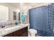 The bathroom features a granite vanity and a shower with a blue wave shower curtain at 8244 W Albeniz Pl, Phoenix, AZ 85043