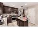 Galley kitchen with a center island, tile floors, and stainless steel appliances at 8244 W Albeniz Pl, Phoenix, AZ 85043