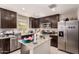 Well-lit kitchen featuring granite countertops, stainless steel appliances, and dark wood cabinets at 8244 W Albeniz Pl, Phoenix, AZ 85043
