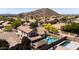 Aerial view of a two-story house with a backyard oasis, desert landscaping, pool and outdoor living spaces, and mountain views at 9052 E Hobart St, Mesa, AZ 85207