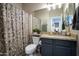 Bathroom featuring a shower with decorative curtain and dark vanity with light countertop at 9052 E Hobart St, Mesa, AZ 85207