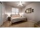 Cozy bedroom with neutral tones, ceiling fan, and decorative mirror above the bed at 9052 E Hobart St, Mesa, AZ 85207