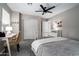 Comfortable bedroom featuring neutral tones, a ceiling fan, and a dedicated desk space for work or study at 9052 E Hobart St, Mesa, AZ 85207