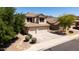 Inviting two-story home with a three-car garage, beautiful desert landscaping, and mature shade trees at 9052 E Hobart St, Mesa, AZ 85207