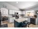 Bright kitchen features white cabinets, granite countertops, stainless steel appliances, and a large island with seating at 9052 E Hobart St, Mesa, AZ 85207