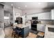 Spacious kitchen with granite countertops, white cabinetry, stainless steel appliances, and a center island with seating at 9052 E Hobart St, Mesa, AZ 85207