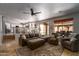 Open living area with a sectional sofa, comfortable chairs, natural lighting, and access to a loft above at 9052 E Hobart St, Mesa, AZ 85207