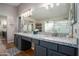 Elegant main bathroom featuring dual sinks, granite counters, and a large framed mirror at 9052 E Hobart St, Mesa, AZ 85207