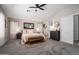 Spacious main bedroom featuring neutral decor, soft carpet, and a comfy king-size bed with ceiling fan at 9052 E Hobart St, Mesa, AZ 85207