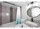 Bathroom with modern vanity, oval mirror and tiled shower/tub with stylish shower curtain at 10828 N Biltmore Dr # 230, Phoenix, AZ 85029