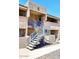 Inviting two-story condo with exterior staircase and neutral-toned stucco under a clear blue sky at 10828 N Biltmore Dr # 230, Phoenix, AZ 85029