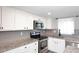 Close-up of the kitchen showcases stainless steel appliances, granite counters, and white cabinetry with stylish hardware at 10828 N Biltmore Dr # 230, Phoenix, AZ 85029