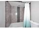 Tub and shower combo with custom shower curtain and gray tiled surround at 10828 N Biltmore Dr # 230, Phoenix, AZ 85029