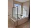 Modern bathroom featuring a soaking tub, tiled walls, and a bright window at 11074 W Tonto St, Avondale, AZ 85323