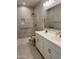 Accessible bathroom featuring double sinks, a tiled shower with grab bars, and modern fixtures at 11074 W Tonto St, Avondale, AZ 85323