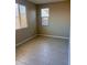 Bright bedroom with tile floors, two windows with blinds, and neutral wall paint at 11074 W Tonto St, Avondale, AZ 85323