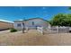 Wide backyard space with desert landscaping, white picket fence, and mature trees at 11596 W Sierra Dawn Blvd # 33, Surprise, AZ 85378