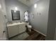 Bright bathroom featuring dark wood floors, a white vanity, and decorative wall shelving at 11596 W Sierra Dawn Blvd # 33, Surprise, AZ 85378