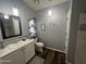 Bathroom showcases dark wood floors, white vanity, wall decor, and mosaic backsplash at 11596 W Sierra Dawn Blvd # 33, Surprise, AZ 85378