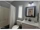 Cozy bathroom featuring a white vanity with a black framed mirror, a toilet, and a shower/tub with a white curtain at 11596 W Sierra Dawn Blvd # 33, Surprise, AZ 85378