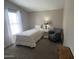 Comfortable bedroom with a twin bed, gray armchair, side table, and large window providing natural light at 11596 W Sierra Dawn Blvd # 33, Surprise, AZ 85378