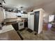 A well-equipped kitchen with white cabinets, a refrigerator, and a view to a room with wood floors at 11596 W Sierra Dawn Blvd # 33, Surprise, AZ 85378