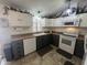 Well-lit kitchen showcasing white and gray cabinets, an electric range, and a bright window over the sink at 11596 W Sierra Dawn Blvd # 33, Surprise, AZ 85378