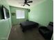 Bedroom with carpeted floor features a black bed, ceiling fan, and a green painted wall at 11644 W Redfield Rd, El Mirage, AZ 85335