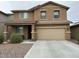 Two-story home featuring a two-car garage, covered porch, and a well-maintained front yard at 11644 W Redfield Rd, El Mirage, AZ 85335
