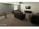 Spacious living area features carpeted floors, a TV, sofas, and a foosball table at 11644 W Redfield Rd, El Mirage, AZ 85335