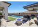 Resort-style backyard with pool, outdoor kitchen, covered patio, and a cozy fire pit area at 11807 W Parkway Ln, Avondale, AZ 85323