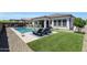 Inviting backyard with a sparkling pool, lounge chairs, manicured turf, and covered patio at 11807 W Parkway Ln, Avondale, AZ 85323