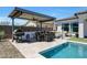 Beautiful backyard oasis with pool, outdoor kitchen, covered patio, and comfortable seating at 11807 W Parkway Ln, Avondale, AZ 85323