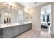 Large bathroom with dual sinks, a large window, and access to the Primary bedroom at 11807 W Parkway Ln, Avondale, AZ 85323