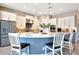 Modern kitchen features white cabinetry, stainless steel appliances, and a center island with seating at 11807 W Parkway Ln, Avondale, AZ 85323