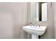 Elegant powder room features a pedestal sink and decorative textured walls at 11807 W Parkway Ln, Avondale, AZ 85323