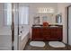 Bathroom with double sinks, dark wood cabinets, a bathtub, and a separate shower at 1281 E Frances Ln, Gilbert, AZ 85295