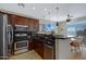 Well-equipped kitchen with stainless steel appliances, dark cabinetry, and an eat-in bar area at 1281 E Frances Ln, Gilbert, AZ 85295