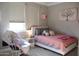 Bright bedroom with cozy decor, soft pink accents, and natural light, creating a serene and inviting space at 13686 N 151St Dr, Surprise, AZ 85379