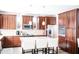 Well-lit kitchen with wooden cabinetry, stainless steel appliances, mosaic backsplash, and a kitchen island with white chairs at 13686 N 151St Dr, Surprise, AZ 85379