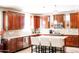Bright kitchen with dark wood cabinets, white countertops and backsplash, and a kitchen island with seating at 13686 N 151St Dr, Surprise, AZ 85379