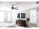 Bedroom featuring white shuttered windows, a dark wood dresser, and a ceiling fan at 13686 N 151St Dr, Surprise, AZ 85379