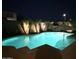Night view of a backyard pool with stylish palm trees and inviting ambiance for relaxation at 13686 N 151St Dr, Surprise, AZ 85379