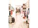 Spacious walk-in closet with custom shelves, hanging racks, and a view to another closet through the door at 13686 N 151St Dr, Surprise, AZ 85379