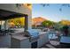 Outdoor kitchen area with stainless steel grill, pool views, natural landscaping, and mountain views beyond at 14045 E Geronimo Rd, Scottsdale, AZ 85259