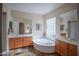A bright primary bathroom with a garden tub, dual vanities, and a large mirror at 14045 E Geronimo Rd, Scottsdale, AZ 85259