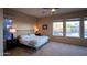 Bright main bedroom with plush carpet, neutral walls, a ceiling fan, and large windows offering backyard views at 14045 E Geronimo Rd, Scottsdale, AZ 85259