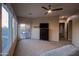 Bright main bedroom with plush carpet, neutral walls, a ceiling fan, and sliding glass door leading to the backyard at 14045 E Geronimo Rd, Scottsdale, AZ 85259
