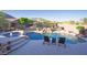 Backyard pool surrounded by rock accents, complemented by lounge chairs, natural vegetation, and a waterfall feature at 14045 E Geronimo Rd, Scottsdale, AZ 85259